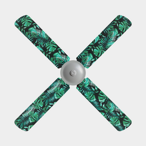 Four blade ceiling fan with fan covers with black background and large green leaves and ferns