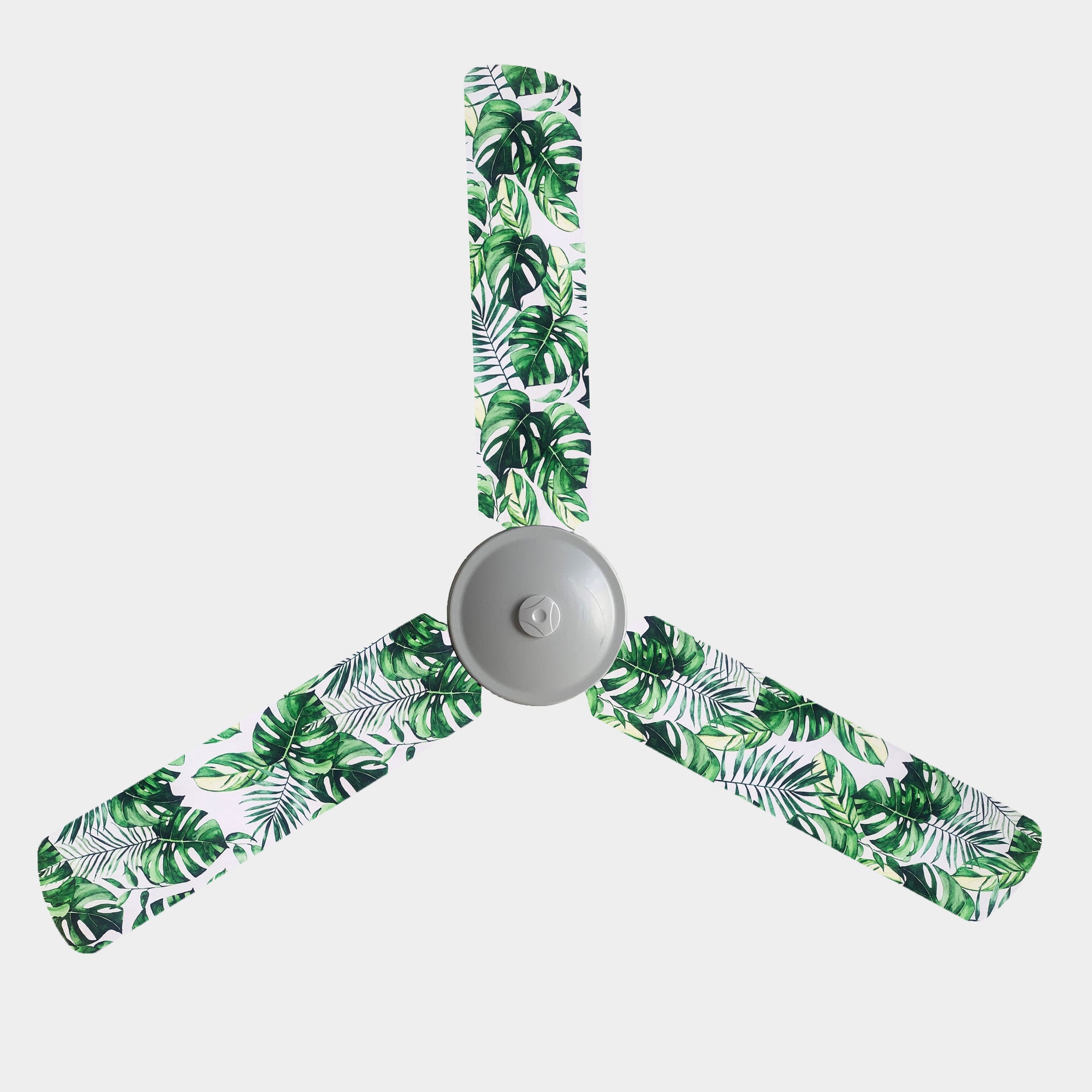 Green monstera leaves and green fern print fanblade covers on a white background